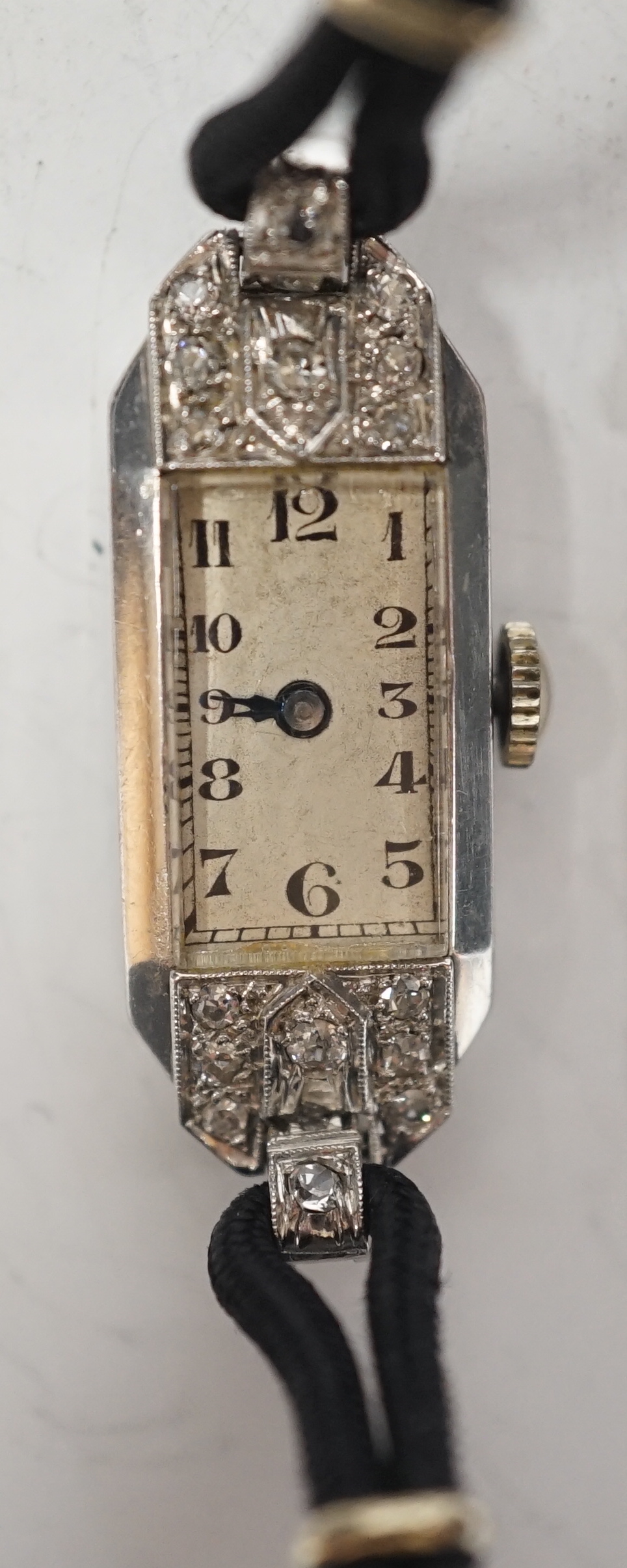 A lady's mid 20th century white metal, inscribed 'All Platinum' and diamond chip set rectangular manual wind cocktail wrist watch, on a twin fabric strap with sterling clasp, cased diameter 13mm.